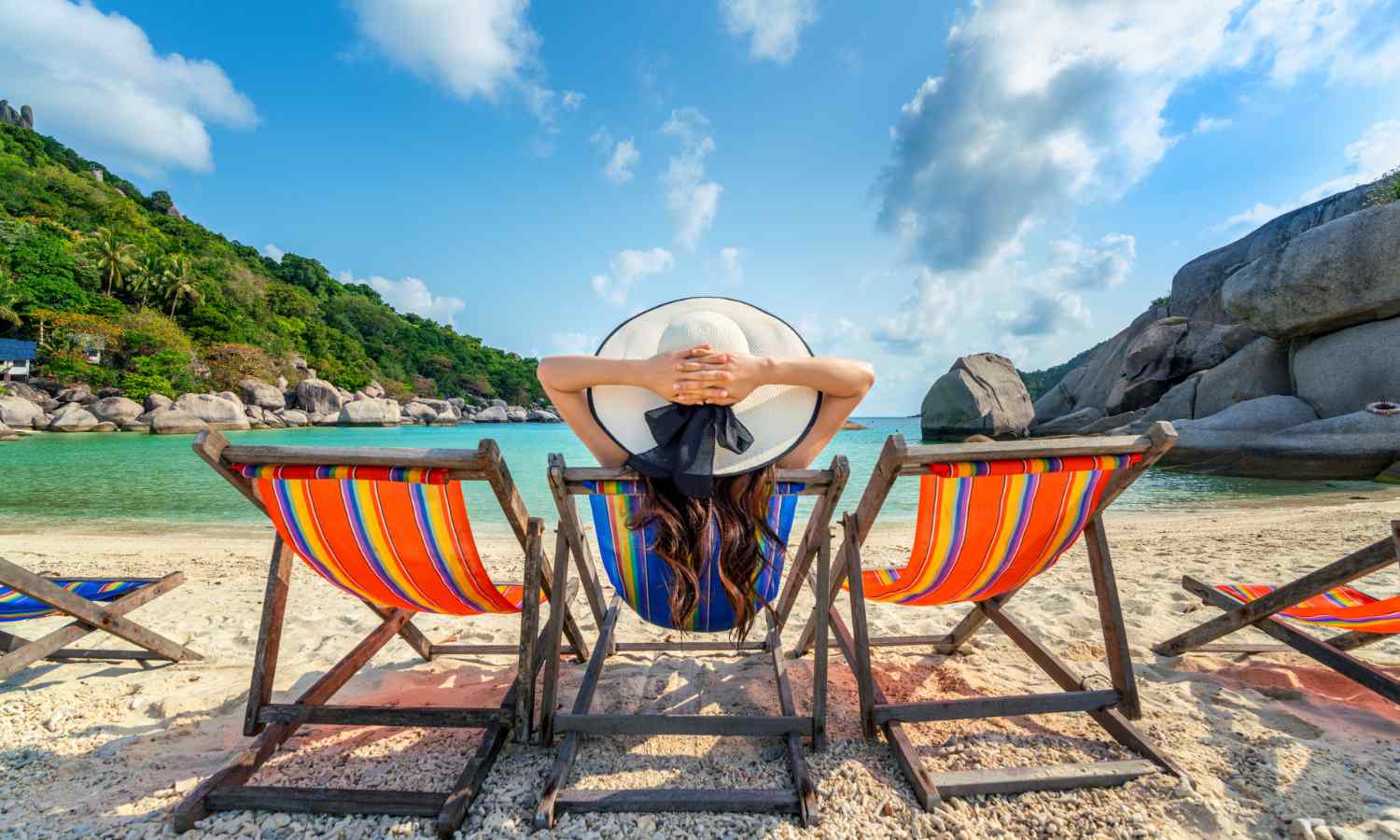 Woman with hat sitting on chairs beach in beautiful tropical beach. Woman relaxing on a tropical beach at Koh Nangyuan island. Image by tawatchai07 on Freepik